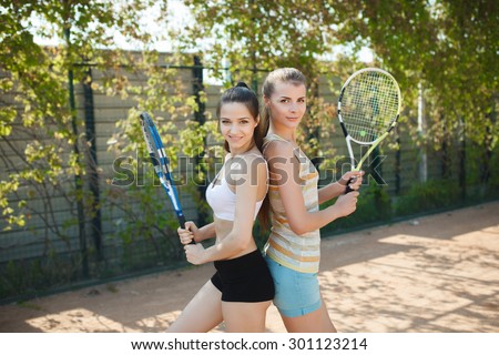 young women playing doubles at tennis at the tennis court