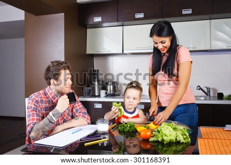 little girl cutting vegetables with her mother in the kitchen, stylish people, hipsters