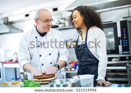 young girl learns to bake cakes with porfessionalnym baker