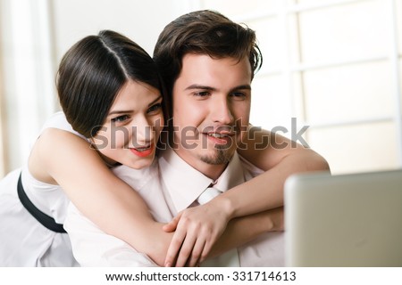 happy young relaxed couple working on laptop computer