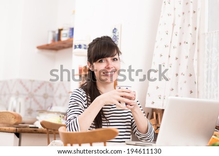 Happy young beautiful woman holding cup of tea in old fashioned Czech cottage in countryside