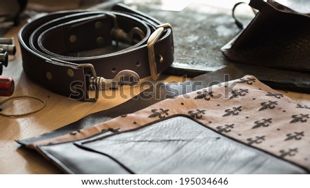 Composition of leather pieces of the leather bag on working desk with a low depth of field