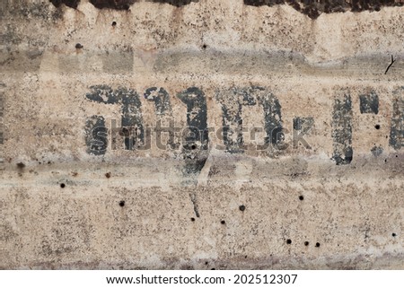 Texture of old desaturated beige metal with hebrew letters