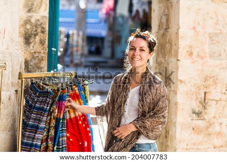 Young beautiful woman shopping some muslim goods in the old market in Old Town in Jerusalem.