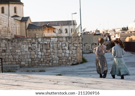 Two girls walking in the Old City in Jerusalem in Israel at the foot of the western side of the Temple Mount.