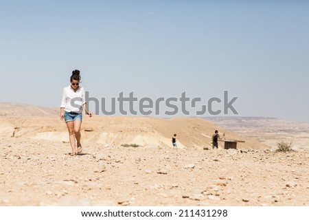 Attractive woman walking in the Negev desert in Israel. Girl enjoying the vocation.