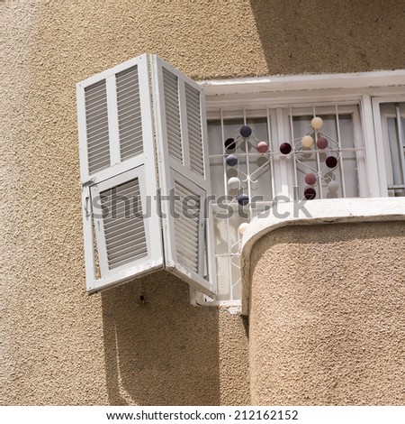 Old window with white window shutter and balcony in Tel Aviv. Detail of Bauhaus style.