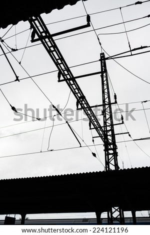 Silhouette of pole and wires of vintage train station in Bohemia. Black and white photography.