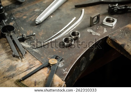 Working desk for craft jewelery making with professional tools. Still life of goldsmith\'s tools with rings.
