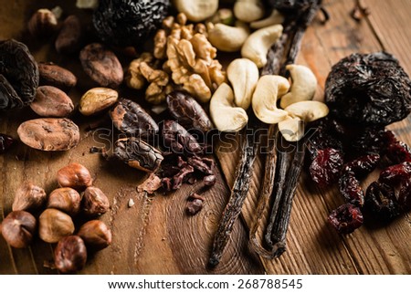 Hazelnuts, walnuts, cashews and vanilla orchid pod on the grunge table or desk in the kitchen. Composition of the ingredients for cooking cakes or ice cream.