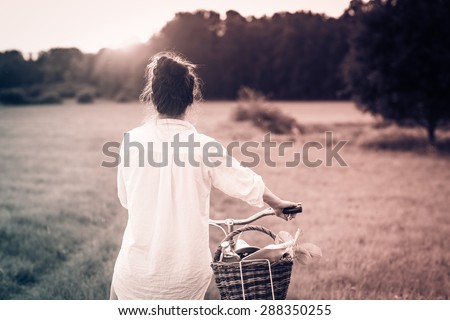 Woman riding bicycle with the basket of fresh food. Black and white photography.