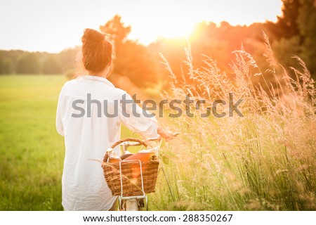 Woman riding bicycle with the basket of fresh food.
