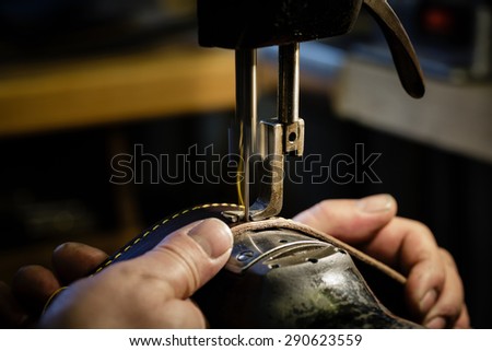 Sewing process of the leather belt. Man\'s hands behind sewing. Leather workshop.