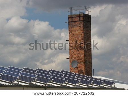 Roof with solar panely and chimney as a symbol for energy revolution.