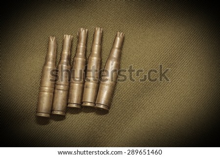 Bullet casings on textile with sepia effect and vignetting.