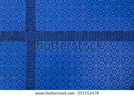 Abstract shot of a floor mat pattern with cross shaped part, resembling a Nordic Cross.