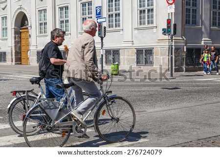 Copenhagen - June 11: Men riding bicycles along Nyhavn waterfront, June 11, 2013, Copenhagen, Denmark