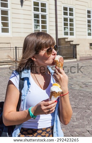 Young happy girl eating ice cream on Market Square,  Lviv, Ukraine