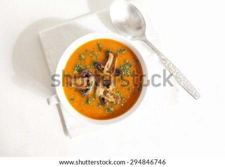 Tomato soup with mushrooms on a light background
