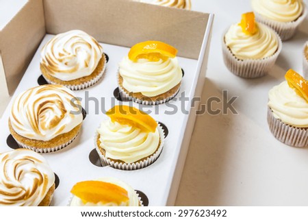 Lemon cupcakes with meringue and orange cupcakes in a box