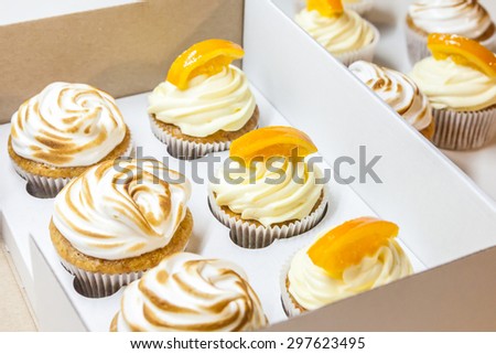 Lemon cupcakes with meringue and orange cupcakes in a box