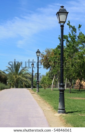 Line of lampposts along a park lane in a Spanish park.