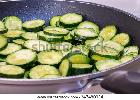 closeup of sliced zucchini while cooking in the pan