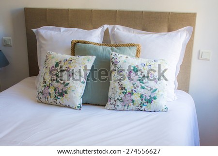 soft white and colored pillows on a comfortable bed
