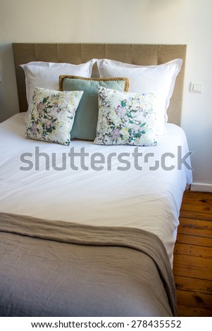 Soft white and colored pillows on a comfortable bed