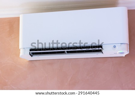 white air conditioner installed on a pink wall