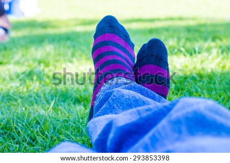closeup of colored socks of a teenager who is resting in a park