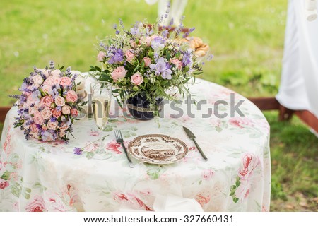 Served table outdoors. Flower arrangement with lavender and roses. Wedding decorations.