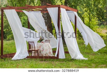 Outdoor gazebo with white curtains. Wedding decorations. Art object.