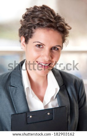 Portrait of beautiful businesswoman smiling and holding a flip chart