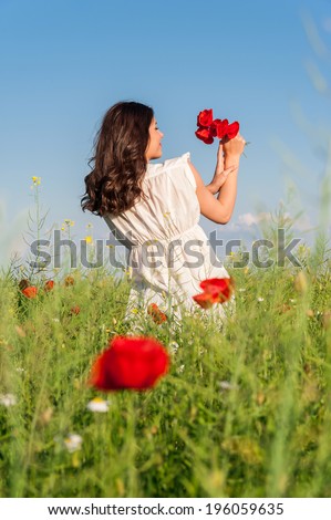 Young beautiful calm girl dreaming on a poppy field, summer outdoor. Freedom concept. Series. Free Happy Woman Enjoying Nature