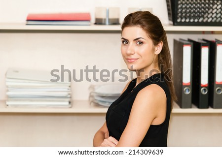 Closeup of relaxed young beautiful young business woman smiling at office
