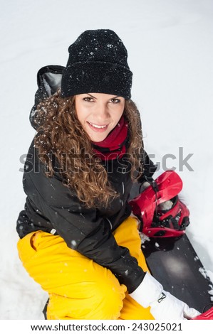 Happy Young Female Snowboarder outdoors, holding a snowboard
