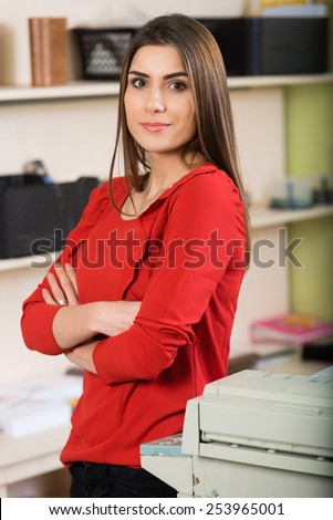 Relaxed young beautiful young business woman smiling at office,arms crossed