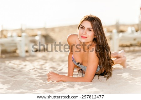 Happy sunshine woman. Girl smiling friendly looking at camera on sunny summer day under the hot sun on beach.