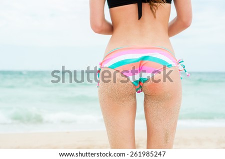 Woman on beach, Rear view of young beautiful girl wearing bikini, standing back looking to sea blue sky horizon, vacation concept of travel ocean. Close-up,no face.