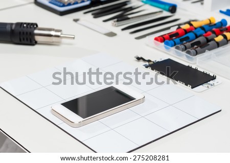 Close-up photos of mobile phones in a repair atelier.