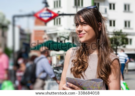 Young tourist woman in front of Madrid, Banco de Espana metro station.