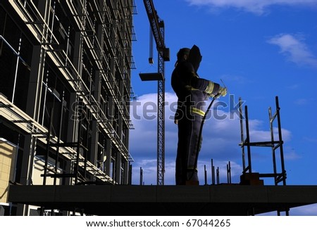 Silhouette of the worker on a background of the sky