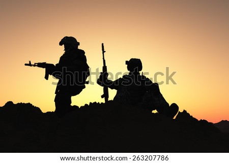 Silhouettes of soldiers against the sky.