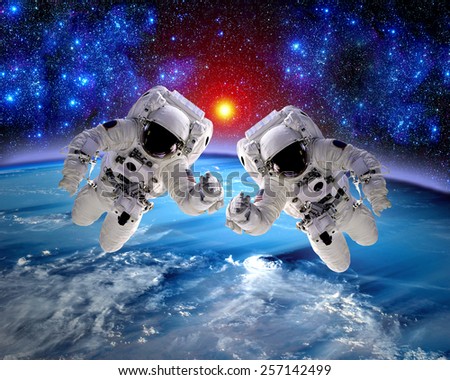 Astronaut spaceman outer space teamwork hands earth people. Elements of this image furnished by NASA.