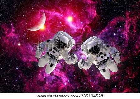 Two astronauts spacemen suit outer space moon galaxy universe. Elements of this image furnished by NASA.