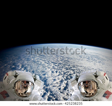 High resolution planet Earth two astronauts spaceman helmet suit floating people outer space walk. Elements of this image furnished by NASA.