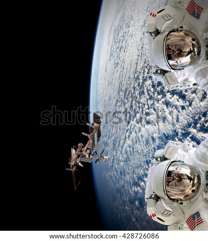 Planet Earth two astronauts spaceman helmet suit outer spacewalk international space station. Elements of this image furnished by NASA.