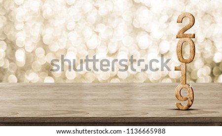 Happy New Year 2019 wood with sparkling star on brown wood table with gold bokeh background,Holiday festive celebration concept.Banner mock up for display of product or design content