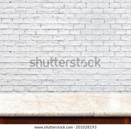 marble table and white brick wall in background. product display template.
